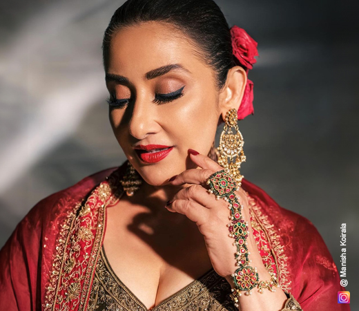 Manisha Koirala wearing jewellery with a red suit
