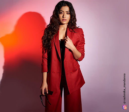 Rashmika Mandanna wearing a red blazer and trousers
