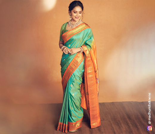 Madhuri Dixit wearing a green and orange saree
