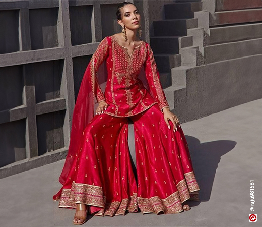 girl sitting in a red sharara