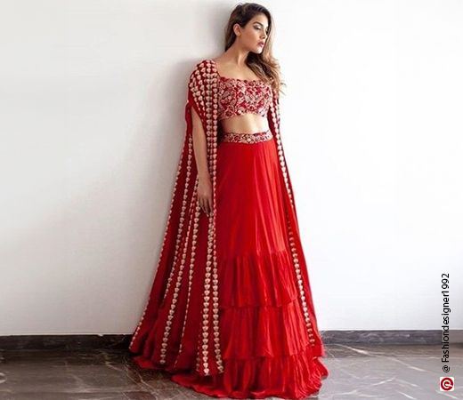 woman in a red lehenga with a cape on shoulder