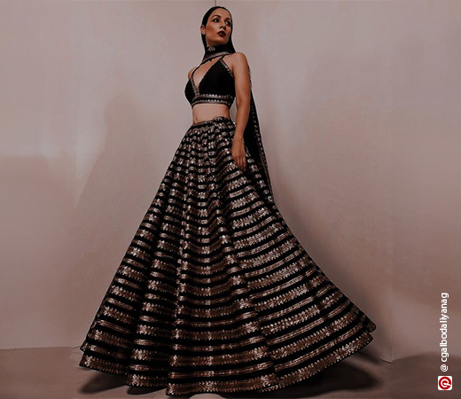 woman in a black lehenga with golden work on it